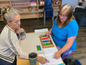 A Picture from the Montessori Experience event with two instructors going through guided learning sessions.